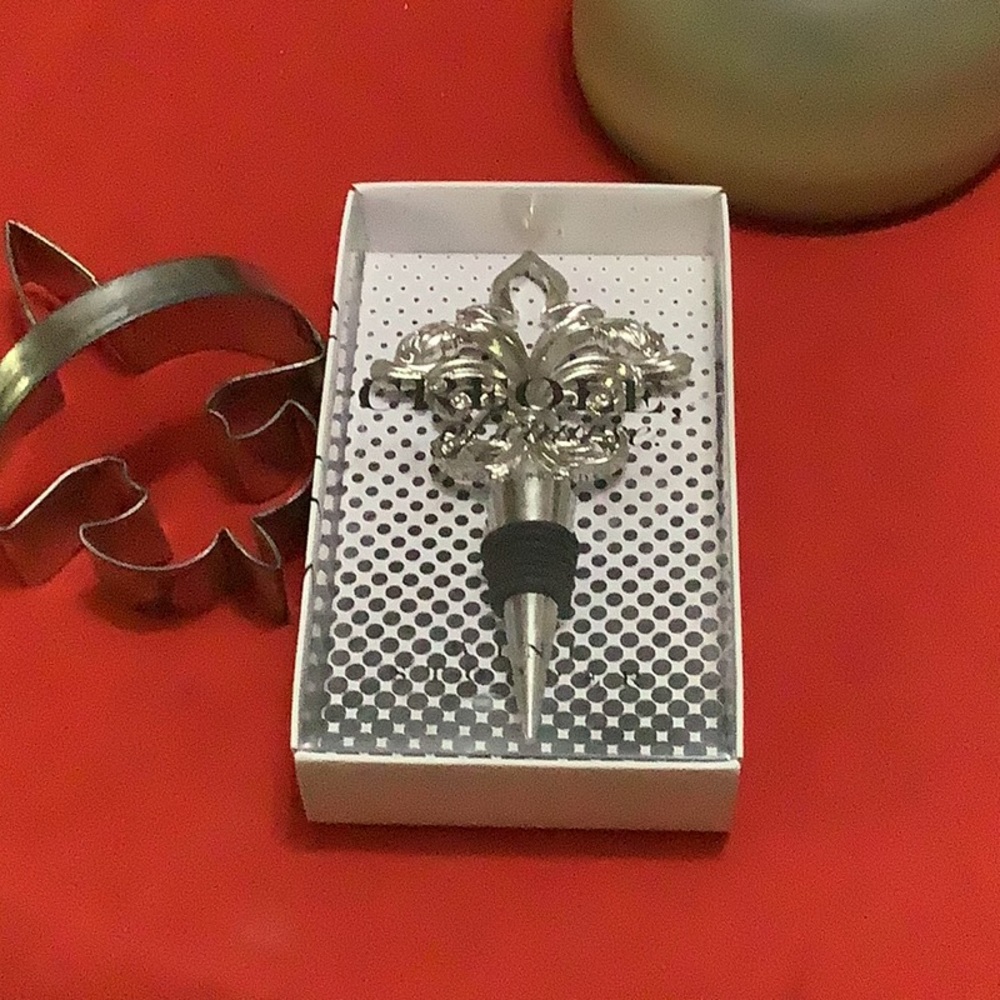 Creole of course. Fleur wine finial. Silver and black. Very ornately design.
